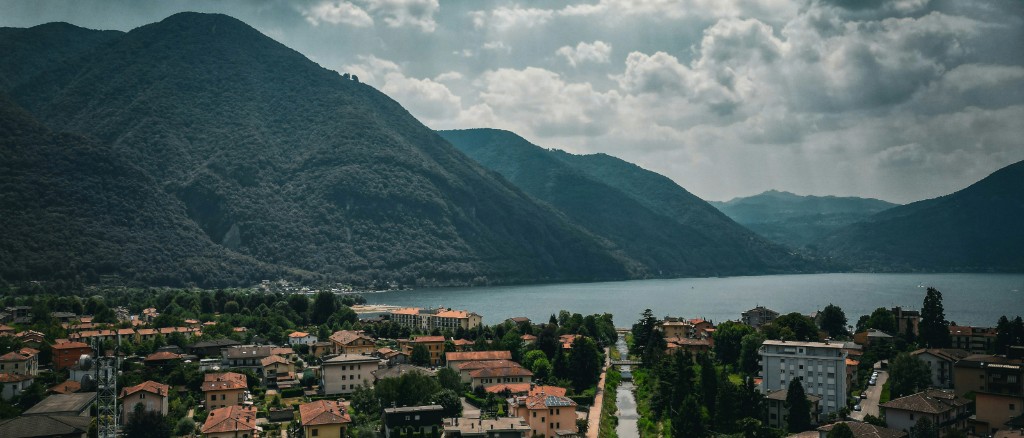 Panoramic view of Porlezza and Lago di Lugano, forested mountains and clouds